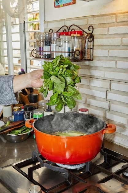 Lo chef ha sbollentato un mazzetto di basilico in una pentola bollente