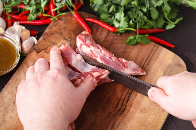 Lo chef macellaio taglio di carne di agnello con coltello