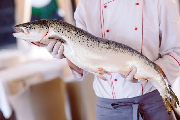 Lo chef mantiene il salmone.