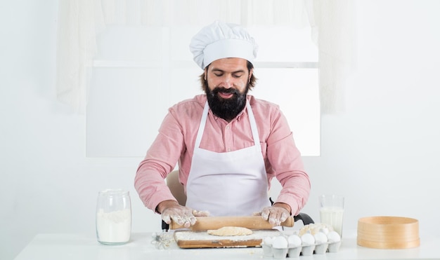 Lo chef maschio con il cappello prepara un pasto sano bell'uomo con barba e baffi che cucina il cibo ristorante professionale cuoco che cucina panettiere esperto usa utensili da cucina per cucinare Nessun grasso saturo