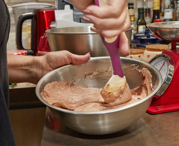 Lo chef mescola la farina di cacao con il resto degli ingredienti nella ciotola per fare la torta