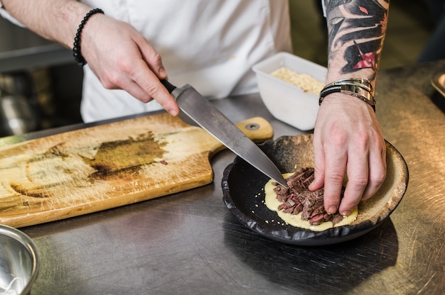 Lo chef prepara filetto di manzo nella cucina del ristorante