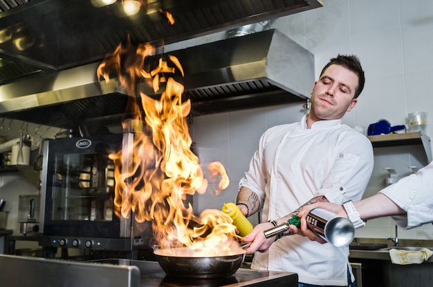 lo chef prepara flambé nella cucina di un ristorante