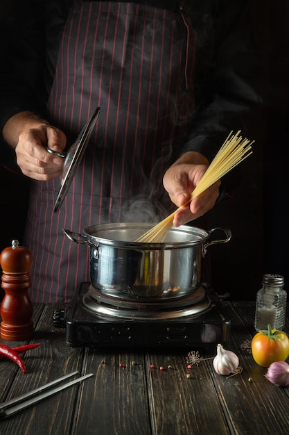 Lo chef prepara la pasta biologica in una pentola calda in cucina Deliziosa ricetta per il cibo dell'hotel