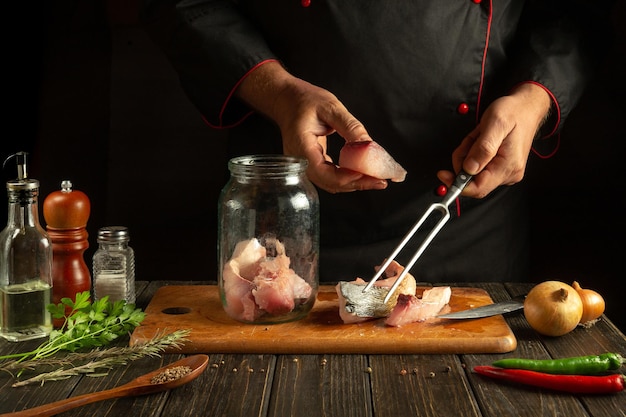 Lo chef prepara pesce carpa a testa grande fresco Preparandosi a cucinare aringhe o pesce salato Ambiente di lavoro nella cucina di un ristorante
