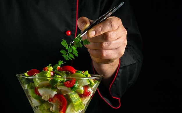 Lo chef prepara un'insalata con verdure fresche nella cucina del ristorante Un piatto di verdure in una ciotola per la colazione Un concetto di cibo sano vegetariano