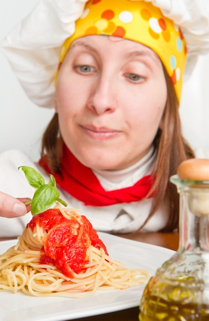 lo chef sorridente guarnisce un piatto di pasta italiana