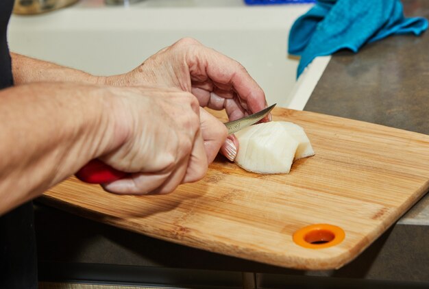 Lo chef sta tagliando la pera per fare la torta