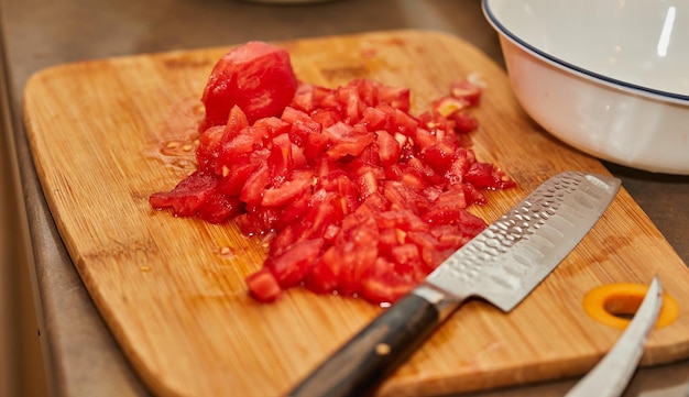 Lo chef taglia i pomodori in piccoli cubi per la cottura