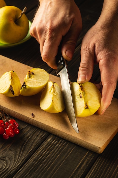 Lo chef taglia le mele su un tagliere per fare una composta o un succo di frutta