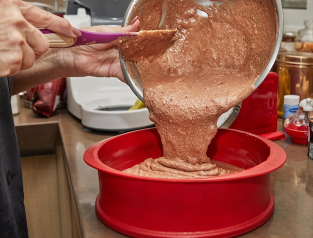 Lo chef versa gli ingredienti della torta dalla ciotola in una teglia in silicone