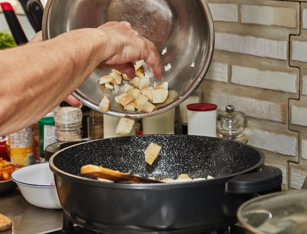 Lo chef versa lo zenzero nella ciotola di cottura