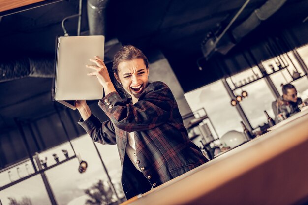 Lo odio. Ragazza castana emotiva che grida pur avendo problemi sul lavoro