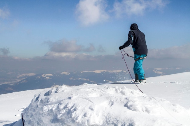 Lo scalatore si prepara a scendere dalla montagna innevata