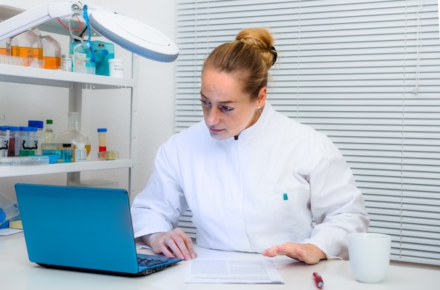 Lo scienziato legge documenti sul computer in laboratorio