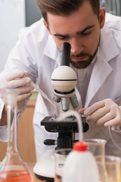 Lo scienziato sta usando il microscopio in un laboratorio durante la ricerca