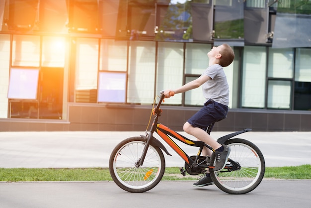 Lo scolaro va in bicicletta. Vacanze estive.