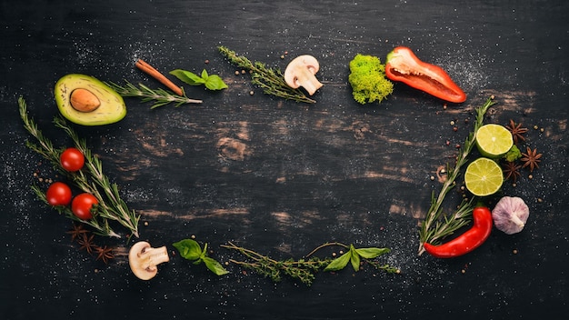 Lo sfondo della cucina Un insieme di spezie e verdure fresche Vista dall'alto Spazio libero per il testo Su uno sfondo di legno