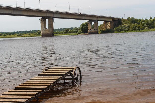 Lo sfondo su un molo di legno sul fiume