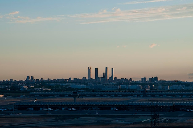 Lo skyline della città di Madrid con le famose 4 torri sullo sfondo e l'aeroporto sottostante al tramonto