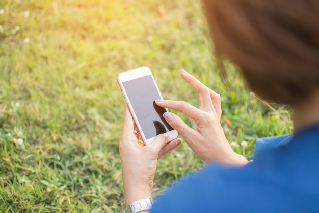 lo smart phone della holding della mano dell&#39;essere umano con la priorità bassa della sfuocatura.