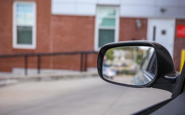 Lo specchietto laterale dell'auto rappresenta la sicurezza della consapevolezza del riflesso e l'estensione visiva del f del conducente