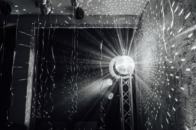 Lo specchio a palla della discoteca gira e riflette la luce nella discoteca del club