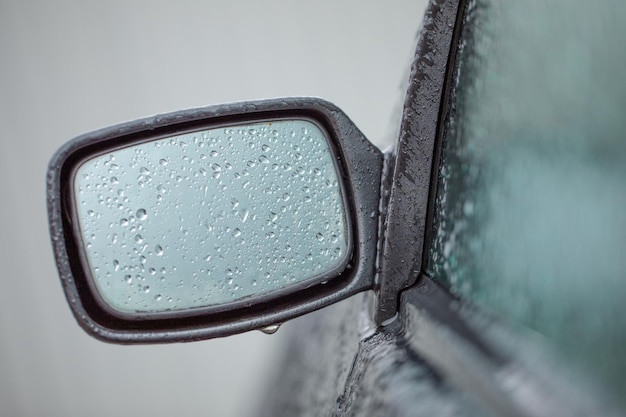 Lo specchio nero dell'auto è coperto da gocce d'acqua o ghiaccio.