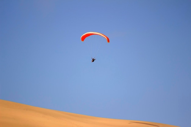 Lo sport del salto dalla duna di sabbia e dell'esecuzione di manovre acrobatiche in aria durante la caduta libera prima dell'atterraggio con il paracadute