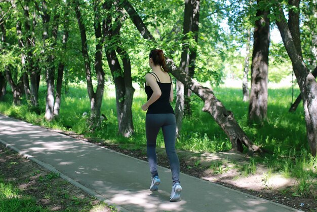 Lo sport della donna corre nel parco all'aperto