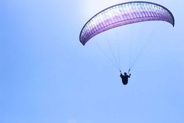 Lo sportivo che vola in parapendio nel cielo azzurro