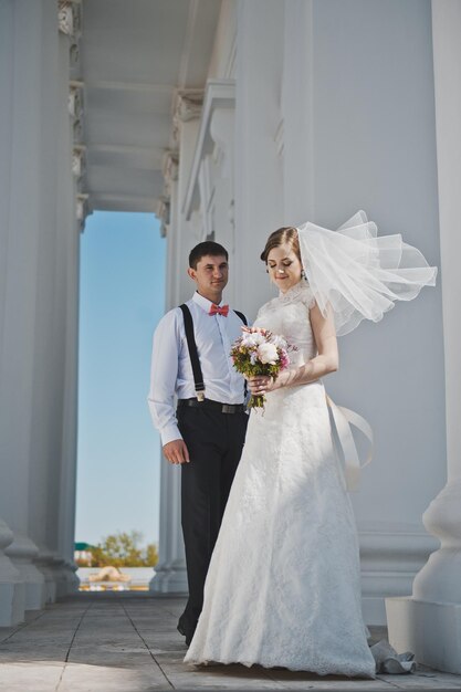 Lo sposo abbraccia la sposa con le colonne bianche 3894