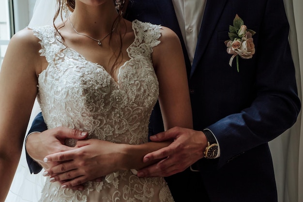 Lo sposo abbraccia la sposa in un abito da sposa in vita 1