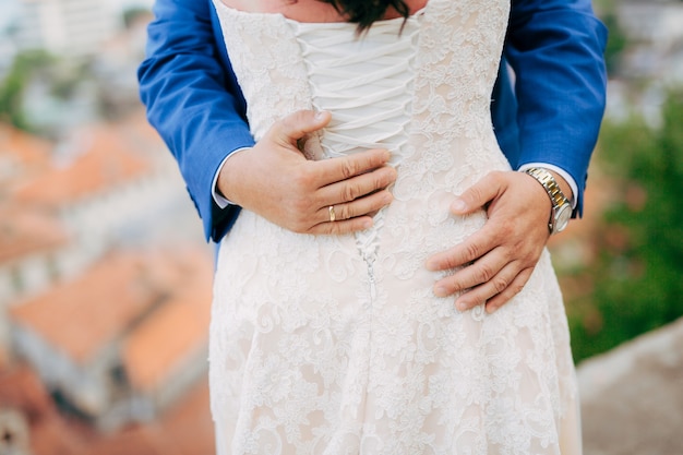 Lo sposo abbraccia la sposa nel centro storico di nozze in montene
