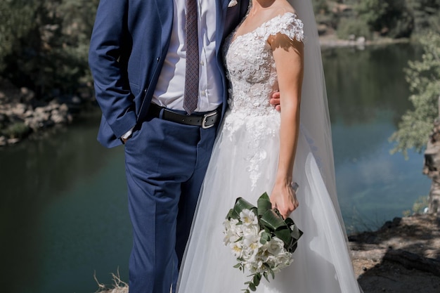 Lo sposo con la sposa sulle pietre vicino al lago