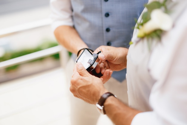 Lo sposo e il testimone sono in piedi sul balcone durante i preparativi per la cerimonia di matrimonio