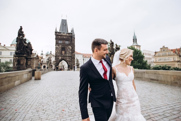 Lo sposo e la sposa camminano sul Ponte Carlo