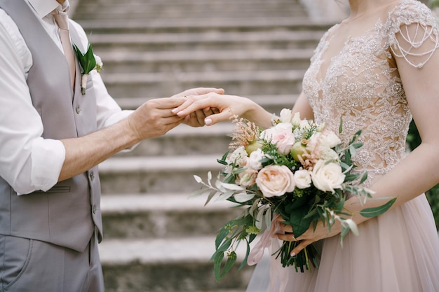 Lo sposo mette l'anello alla sposa stando in piedi sui gradini