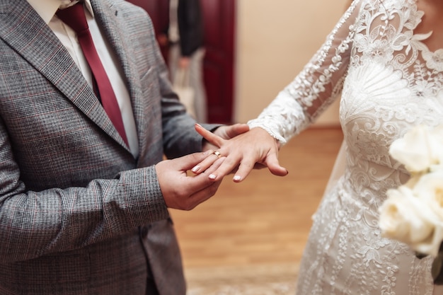 Lo sposo mette un anello d'oro al dito della sposa. Cerimonia matrimoniale