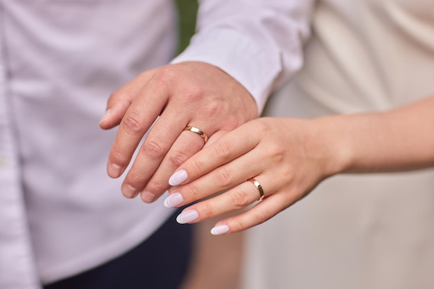 Lo sposo sta mettendo l'anello di nozze sul dito della sposa vista ravvicinata delle mani