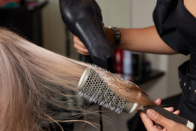 Lo stilista Airtouch fa i capelli bouffant usando il pettine su fili sottili Tecnica Shatush per alleggerire i capelli