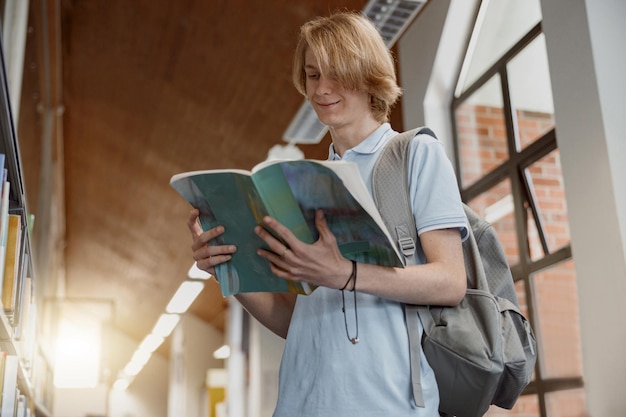 Lo studente legge le note di studio mentre si trova nella biblioteca universitaria Concetto di istruzione