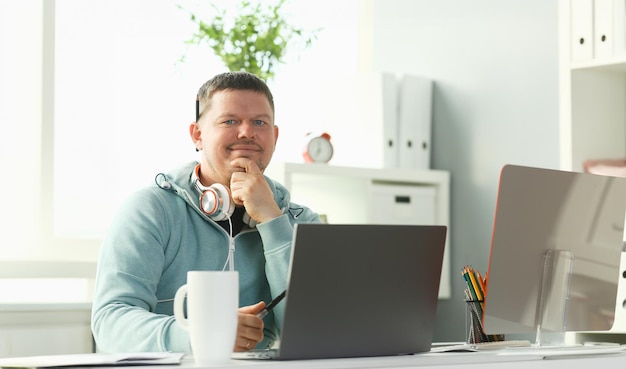 Lo studente maschile sorridente che usa online