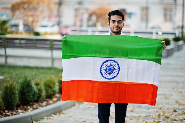 Lo studente maschio indiano asiatico del sud con la bandiera dell'India ha messo all'aperto.