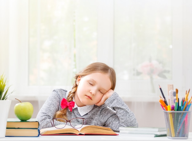 Lo studente seduto al tavolo si addormentò al libro.