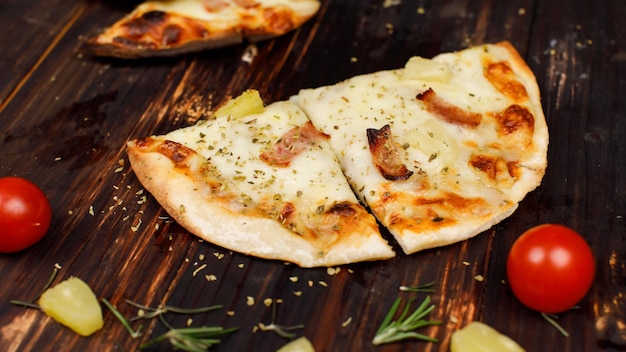 Lo studio del primo piano ha sparato lo chef irriconoscibile usando la buccia della paletta inossidabile che raccoglie il formaggio caldo cotto al forno gustoso delizioso prosciutto italiano fatto in casa ananas pizza tradizionale con crosta di pane hawaiana