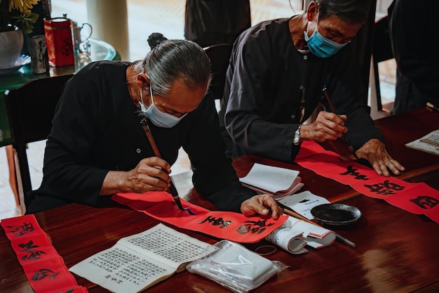 Lo studioso vietnamita scrive la calligrafia al Long Son Il festival della calligrafia è una tradizione popolare durante le vacanze di Tet Scrivere distici per il nuovo anno del Festival di Primavera