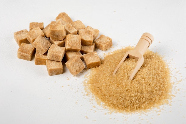 Lo zucchero di canna bruno a pezzi e la sabbia vengono versati in due pile