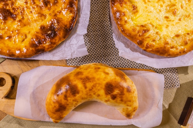 Lobiani e khachapuri freschi su un tavolo di legno in confezione organica. Dolci e cibo tradizionali georgiani.