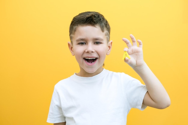 Logoterapia. Il bambino dice la lettera A. Lezioni con un logopedista. ragazzo su sfondo giallo isolato